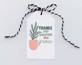 Könnte beinhalten: Ein weißes Geschenk-Etikett mit einer schwarz-weißen Schnurschleife. Das Etikett zeigt eine Pflanzenillustration in einem pfirsichfarbenen Topf mit dem Text "THANKS for helping me grow" in Grün und Grau.