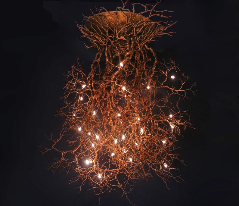 Pu&ograve; includere: Un lampadario unico realizzato con rami naturali e luci bianche calde. I rami sono disposti a cascata, creando un aspetto rustico ed elegante.