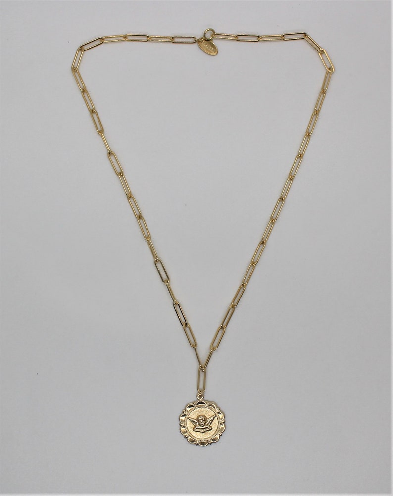 May include: A gold chain necklace with a round pendant featuring an angel design.
