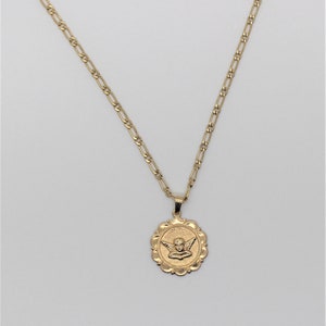 May include: A gold chain necklace with a round pendant featuring a cherub with wings. The pendant has a scalloped edge.