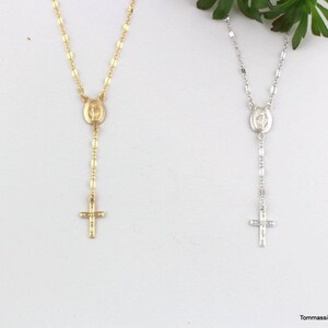 gold and silver chain rosary necklaces with a cross and a small oval mari  pendant. The pendant has a raised image of the Virgin Mary.