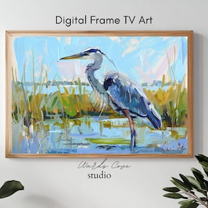 Puede incluir: Una pintura de una garza azul de pie en un pantano. La garza está pintada en un estilo realista con plumas azules, grises y blancas. El fondo es un azul y verde suave, con toques de amarillo y rosa. La pintura está firmada "Wards Cove Studio".