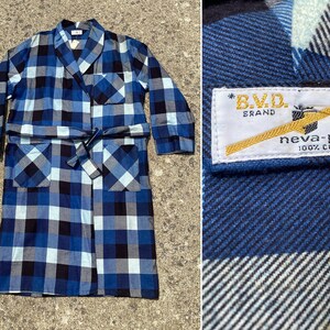 Pode incluir: Um roupão de xadrez azul e branco com cinto para amarrar. O roupão tem dois bolsos e uma etiqueta que diz "B.V.D. Brand neva-press 100% Algodão".
