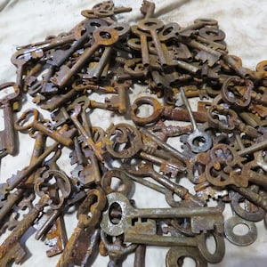May include: A pile of antique keys in various sizes and designs, showing signs of age and rust. The keys are made of metal and have intricate details, with some featuring decorative patterns. The overall color palette is dominated by shades of brown and rust.