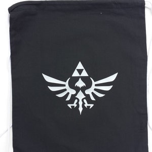 Op de afbeelding: Een zwarte trekkoordtas met een wit Triforce-symbool gedrukt op de voorkant.