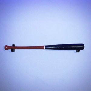 May include: A black wooden baseball bat with a brown handle. The bat has the text "PROVINCIAL CHAMPS" and "ASSOCIATION" printed on it.