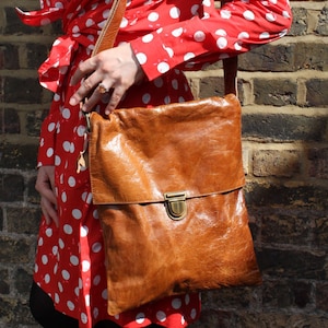 Bolso bandolera push lock de cuero bronceado, bolso mensajero bronceado con cuerpo cruzado, bolso bronceado con correa larga, bolso estilo cartera con cierre push, bolso sobre