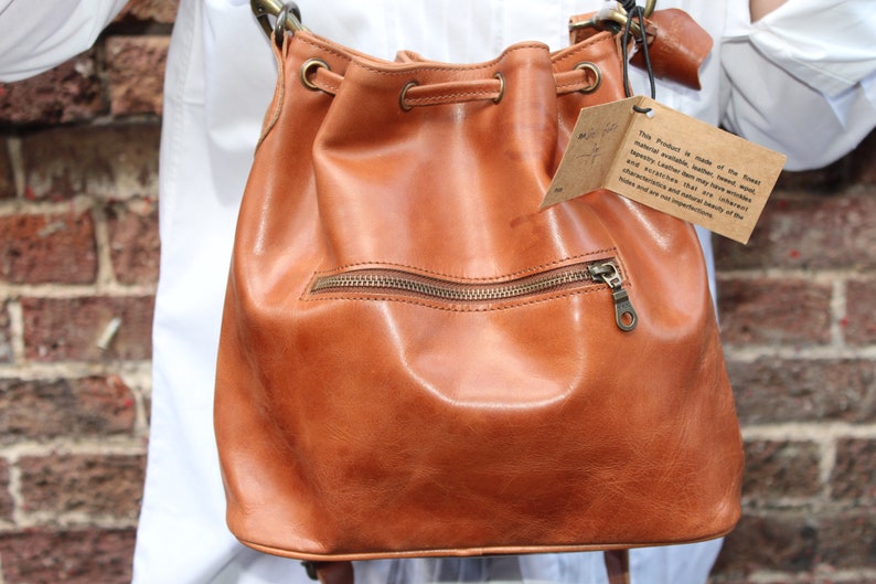 Bucket bag tan leather, Front zip pocket, Shoulder or chest strap, Cross body strap, Inner compartments, Soft leather, Drawstring top purse image 1