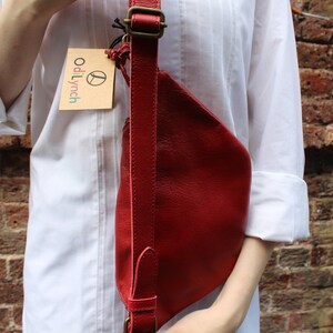 Puede incluir: Un bolso bandolera de cuero rojo con una correa marr&oacute;n y una peque&ntilde;a etiqueta marr&oacute;n que dice "odiLynch".
