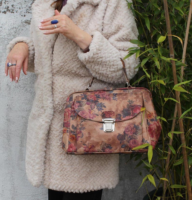 Absolutely stunning rare and unique doctor bag with silver pushlocked front pocket, floral or flowerprinted leather, genuine leather, extra durable lining with both zip and slip pockets, elbow handle and optional long strap a very spacious accessible
