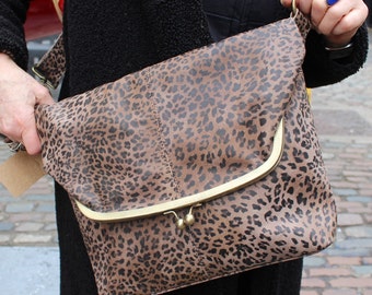 May include: A brown and black leopard print shoulder bag with a gold clasp and a long strap.