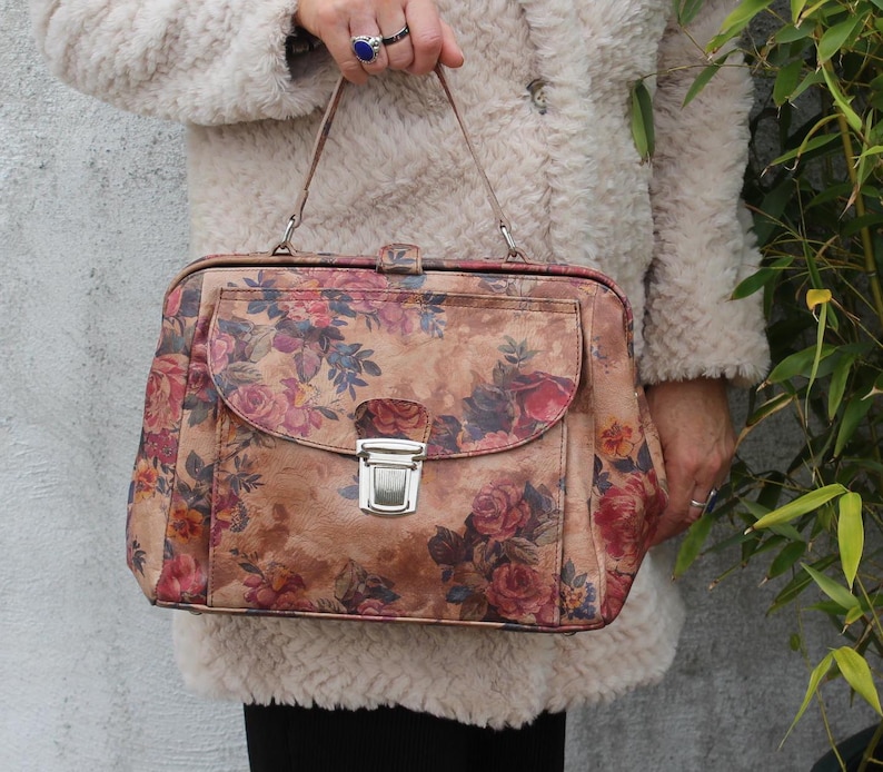 Absolutely stunning rare and unique doctor bag with silver push-locked front pocket, floral or flower-printed leather, genuine leather, extra durable lining with both zip and slip pockets, elbow handle and optional long strap very spacious accessible