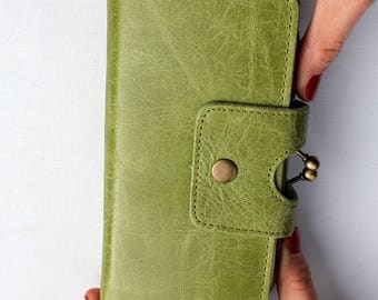 May include: A green leather wallet with a brass clasp and a button closure.
