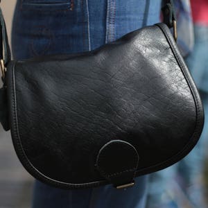 Satteltasche, Schwarzes Leder, Vordertasche, Internes Reißverschlussfach, Verstellbarer Riemen, Glänzendes schwarzes Leder, Handtasche im Stil der 70er Jahre, Crossbody bag