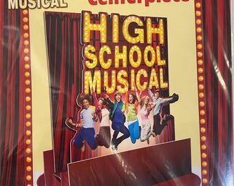 May include: A red and gold cardboard centerpiece featuring the characters from the High School Musical movie. The centerpiece is 12 5/8 inches tall and features the words "High School Musical" in large letters.