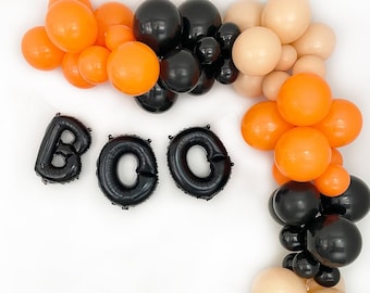 May include: A Halloween balloon garland with black, orange, and beige balloons spelling out "BOO" in black letters.