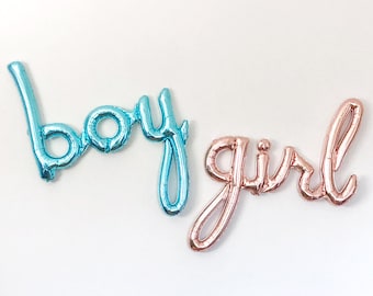 May include: Two foil balloons spelling out "boy" in blue and "girl" in rose gold.
