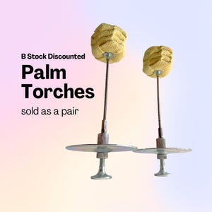 Pode incluir: Duas tochas de palma com cabeças tecidas amarelas, hastes de metal e bases prateadas. O texto na imagem diz "B Stock Discounted Palm Torches sold as a pair."