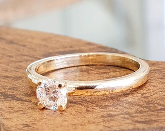 May include: A gold band ring with a single round diamond set in the centre.
