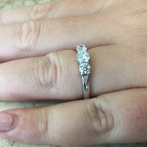 May include: A silver ring with three round diamonds set in a row.