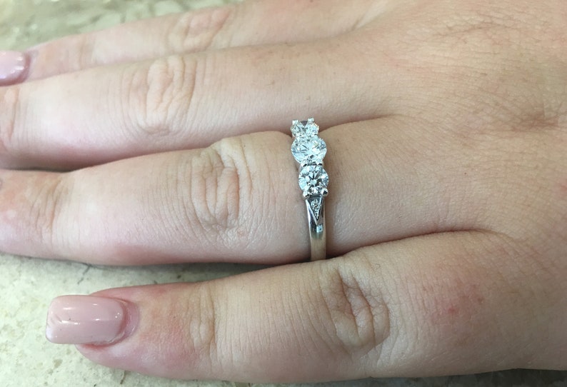 May include: A silver ring with three round diamonds set in a row.
