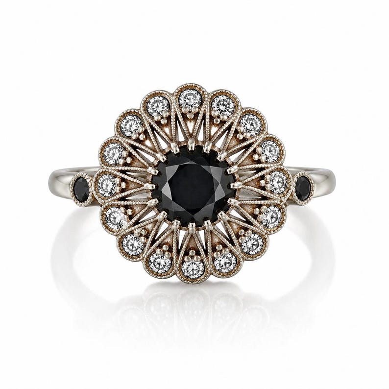 May include: A silver ring with a large black center stone, surrounded by a halo of smaller white stones and a decorative filigree design. Two small black stones are set on either side of the ring's band. The ring has a vintage or antique aesthetic.