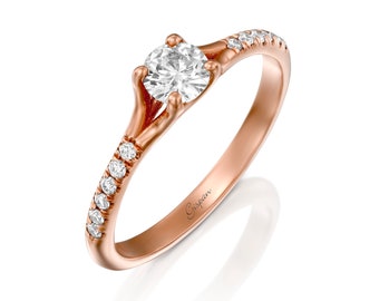 May include: A rose gold engagement ring with a single round diamond and a band of smaller diamonds. The ring is engraved with the word "Gispen".