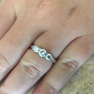 May include: A silver band with five round diamonds set in a graduated row.