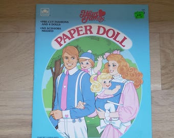 May include: A vintage "Heart Family Paper Doll" book. The cover shows a family illustration within a blue oval frame. The family includes a father, mother, and two children. The book is a Golden Book and includes pre-cut fashions and dolls.