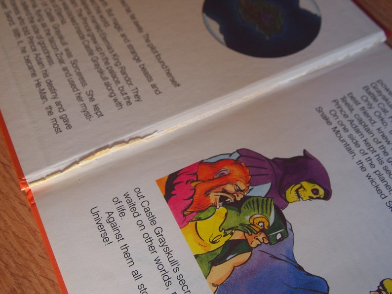 May include: A page from a children's book featuring a comic book style illustration of a group of characters from the Masters of the Universe. The characters are Skeletor, Beast Man, and He-Man. The text on the page reads "Out Castle Grayskull's secret waited on other worlds, of life. Against them all stood the Universe!"