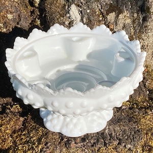 May include: White milk glass candle holder with a scalloped edge and a raised dot pattern. The holder has four candle wells.