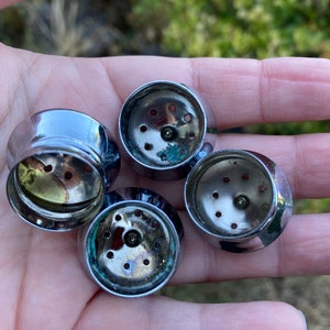 May include: Four silver-colored metal lids with small holes for a spice grinder.