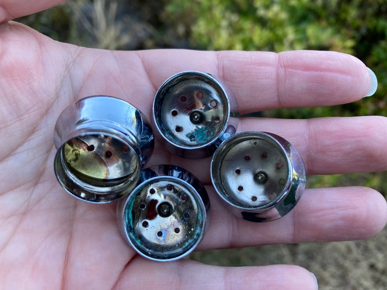 May include: Four silver-colored metal lids with small holes for a spice grinder.