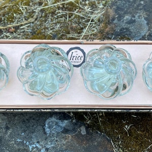 May include: Set of four clear glass cabinet knobs with a fluted design. The knobs are in a box with the text "Irice Product" printed on it.