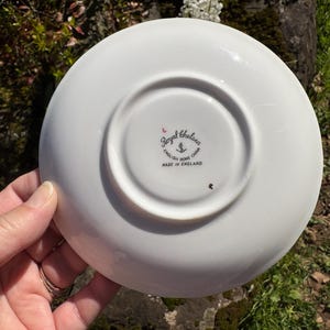 K&ouml;nnte beinhalten: Unterseite einer wei&szlig;en Royal Chelsea English Bone China Untertasse. Die Untertasse hat eine zentrale Vertiefung und einen erh&ouml;hten Rand. Das Royal Chelsea-Logo ist sichtbar, zusammen mit dem Text "MADE IN ENGLAND."