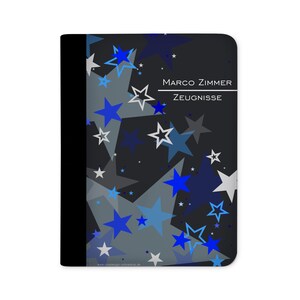 Könnte beinhalten: Schwarzer Ordner mit einem blauen und grauen Sternenmuster. Der Ordner trägt den Text "MARCO ZIMMER ZEUGNISSE" auf der Vorderseite.