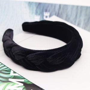 May include: A black velvet headband with a braided design. The headband is thick and wide, and it is perfect for adding a touch of elegance to any outfit.