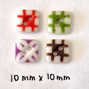 May include: Four square glass buttons, each with a white base and a different colored grid pattern: red, green, purple, and brown. Each button measures 10 mm x 10 mm.