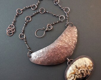 May include: A copper necklace with a hammered copper crescent pendant and a large oval agate stone pendant. The chain is made of twisted copper wire.