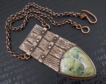 May include: A copper pendant necklace with a rectangular copper piece with a textured wood-like design and three copper bands with rivets. The pendant also features a green and white agate stone in a triangular shape.