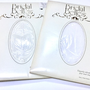 May include: Two packages of "Bridal Belles" sheer hosiery. The packages are white with an oval window showing the contents. The text "Bridal Belles" is at the top, with decorative flourishes. The text "Elegantly refined hosiery to complete your most important ensemble" is at the bottom.