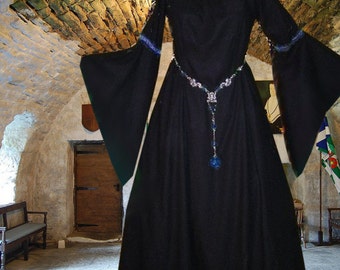 May include: A black medieval-style dress with long sleeves and a jewel-encrusted belt. The dress is flowing and has a simple, elegant design.