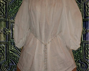 May include: White peasant blouse with a gathered neckline and long sleeves. The blouse is cinched at the waist with a beaded chain.