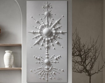 May include: A white 3D wall sculpture with a geometric design of circles and lines. The sculpture is hanging on a white wall in a modern living room with a brown leather chair and a shelf with decorative objects.