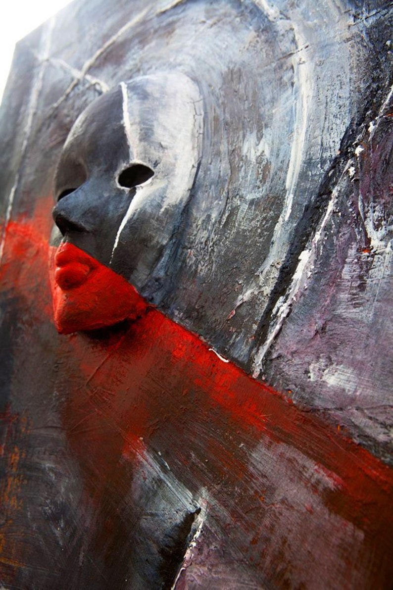 May include: Abstract painting with a textured surface. The painting features a black and white mask with a red mouth, set against a background of gray, white, and red paint.