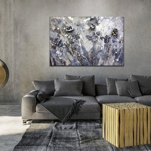 May include: A contemporary living room with a grey sofa, rug, and a wooden coffee table. Above the sofa hangs a large abstract painting of grey and blue roses. A fireplace provides a warm ambiance to the room.
