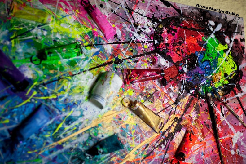 May include: A close-up of a colorful abstract painting with splatters of paint and tubes of paint on a canvas. The painting is in shades of red, pink, green, blue, yellow, and black. The text "Anna Marija Bulka" is visible in the upper right corner of the image.
