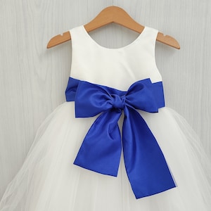 white dress blue satin sash Girls in White Sashes with Blue Satin Sashes