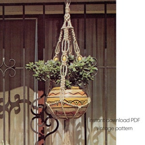 Może przedstawiać: Wieszak na rośliny z makramy w stylu vintage z wzorzystą ceramiczną donicą wypełnioną zielonymi roślinami. Donica ma żółto-pomarańczowy wzór. Widoczny jest tekst "Instant download PDF vintage pattern".