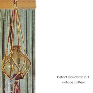 Puede incluir: Un colgador de plantas de macramé vintage con un jarrón de vidrio transparente. El macramé está hecho de cuerda marrón y amarilla, y el jarrón tiene forma redondeada. El texto "Instant download PDF vintage pattern" es visible.
